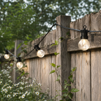 De prikkabel brandend langs een houten schutting, in een tuin
